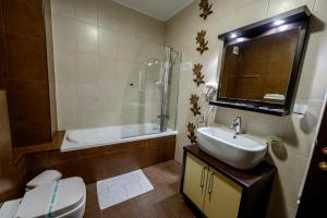 a bathroom with a sink and a toilet and a shower at Samali Residence in Eforie Nord +34 photos