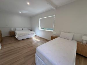 a bedroom with two beds and a window at Midtown Oasis - Sleeps 9 in Scarness +19 photos