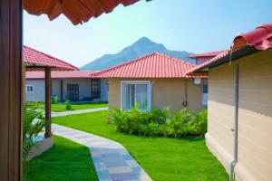 a row of houses with mountains in the background at Anaasa Resorts in Tiruvannāmalai