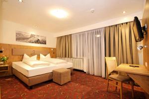 a hotel room with a bed and a desk at Hotel Kajetansbrücke in Pfunds +52 photos