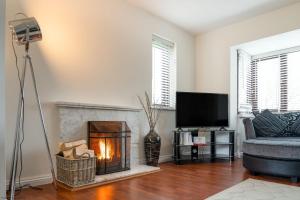 a living room with a fireplace and a tv at Kernow House in Croyde