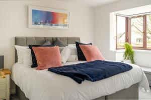 a bedroom with a large bed with colorful pillows at Kernow House in Croyde