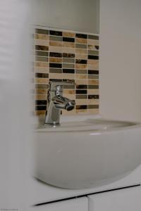 a bathroom sink with a faucet in front of a wall at Kernow House in Croyde +27 photos
