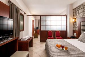 a hotel room with a bed with a tray of fruit on it at City Life Port Hotel in Heraklio