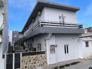 a white building with a balcony on top of it at Veniro Luxury Apartments in Moírai