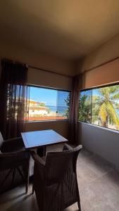 a table and chairs in a room with a view of the ocean at Alfa Beach in Cacha Pregos