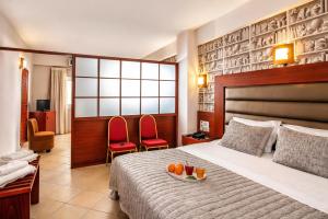 a hotel room with a bed and two red chairs at City Life Port Hotel in Heraklio +30 photos