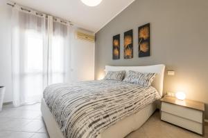 a white bedroom with a bed and a window at Casa Dudú in Quartucciu