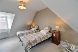 a bedroom with two beds and a night stand with two lamps at Ker'luane in Lézardrieux