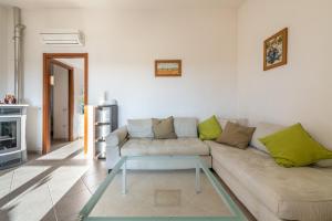 a living room with a couch and a glass coffee table at Casa Dudú in Quartucciu