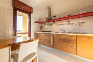 a kitchen with wooden cabinets and a wooden table at Casa Dudú in Quartucciu