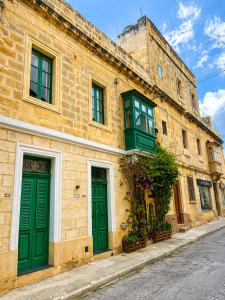 a building with two green doors on a street at Iris -Paola Modern Townhouse in Paola