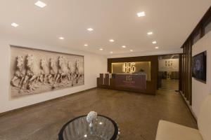 a lobby with a large painting of men on the wall at Hotel Hemaadri Grand in Hyderabad