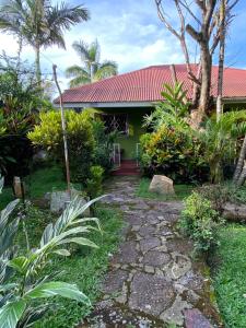 a house with a pathway in front of it at Cross Roads BackPackers Entebbe in Entebbe