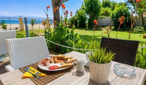 a table with a plate of food on it at Koulouris Beach Hotel in Kavos