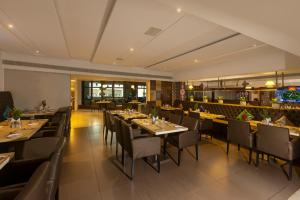 a restaurant with tables and chairs and a bar at Hotel Hemaadri Grand in Hyderabad
