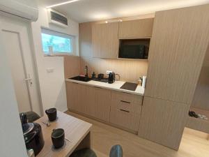 a kitchen with wooden cabinets and a sink and a table at Harbor Hideaway Balatonfüred in Balatonfüred