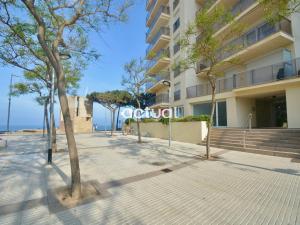 a sidewalk in front of a building with trees at President A-9 in Platja d'Aro
