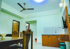 a dining room with a ceiling fan and a table at Ocean Breeze Service Apartment in Malpe