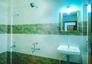 a bathroom with a sink and a mirror at Ocean Breeze Service Apartment in Malpe