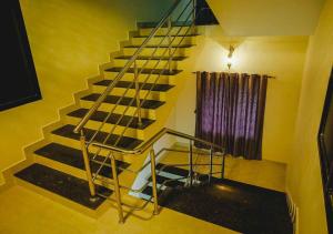 a metal staircase in a room with a window at Ocean Breeze Service Apartment in Malpe
