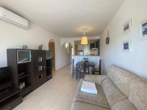 a living room with a couch and a dining room at Apartament Sara in L'Eucaliptus