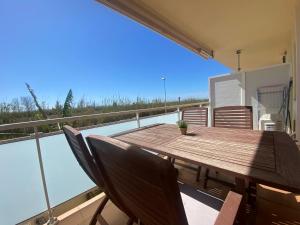 a deck with a wooden table and chairs on a balcony at Apartament Sara in L'Eucaliptus