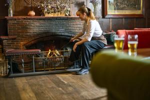 a young girl sitting in front of a fireplace at The Old Bridge in Huntingdon