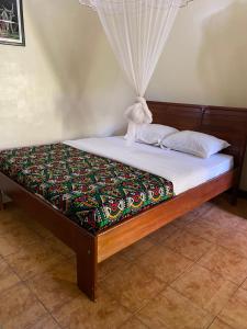 a bed in a room with a curtain on it at Cross Roads BackPackers Entebbe in Entebbe