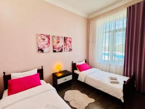 two twin beds in a room with a window at Getaway Nook in Dedoplis Tskaro +67 photos