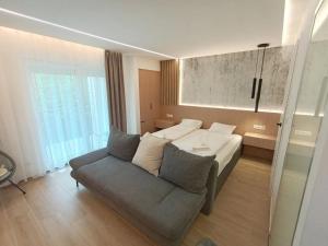 a living room with a bed and a couch at Harbor Hideaway Balatonfüred in Balatonfüred