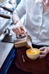 a person is stirring a cup of coffee at The Old Bridge in Huntingdon