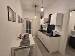 a kitchen with white cabinets and a table in it at Casetta della Lupa in Cernusco sul Naviglio