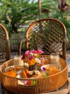 a table with a basket of food and flowers on it at กลิ่นไอทุ่งโฮมสเตย์ in Ban Thum