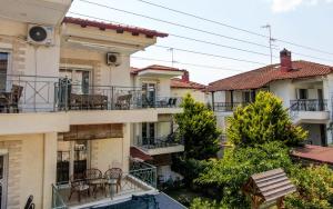 an apartment building with chairs and tables on the balconies at Casa Mameli Αpartments in Kallithea Halkidikis