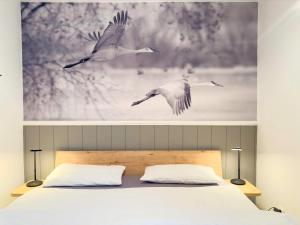 a picture of three birds flying over a bed at Windwatt 2 in Zingst