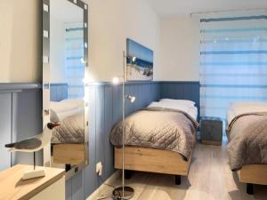 a bedroom with two beds and a mirror at Windwatt 2 in Zingst
