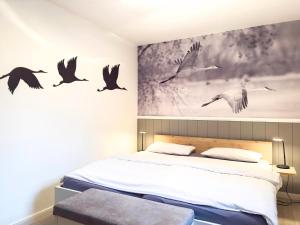 a bedroom with birds flying above a bed at Windwatt 2 in Zingst