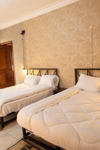 two beds sitting next to each other in a room at UmuTea Villa - Authentic East African local experience in Kigali