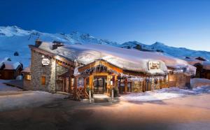 um edifício com luzes de Natal sobre ele na neve em Ancolies Val Thorens em Val Thorens