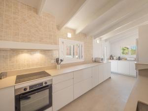 a large white kitchen with white cabinets and appliances at Villa BiniRe by 3VILLAS in Binibeca