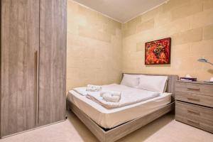 a small bedroom with a bed and a cabinet at Staytopus Offshore Marsalforn Budget Room for Divers & Travelers in Marsalforn