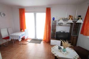 a living room with orange curtains and a tv at Ferienhaus B1 Concordiasee in Friedrichsaue