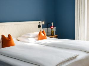 a bedroom with blue walls and a bed with orange pillows at Hotel Kaiserhof Wien in Vienna