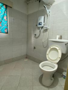 a bathroom with a toilet and a shower at Cross Roads BackPackers Entebbe in Entebbe +63 photos