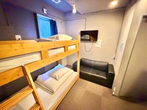 a small room with two bunk beds and a chair at Rhodes Otsuka Hotel in Tokyo