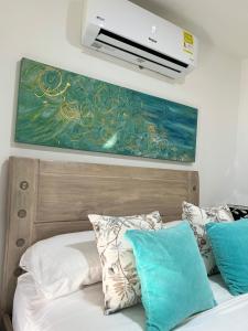 a bedroom with a bed with a painting on the wall at Apartamento COMPLETO Nuevo Norte de Valledupar-1 Habitación, Balcón y Parqueadero in Valledupar +39 photos