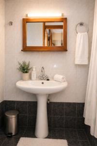 a bathroom with a sink and a mirror at Argyroupolis Dimitris Rooms in Argyroupolis