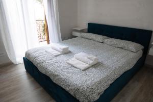 a blue bed with two white towels on it at Residenza Madea - Vista Mare, Piscina, Spiaggia Privata e Parcheggio in Marina di Andora