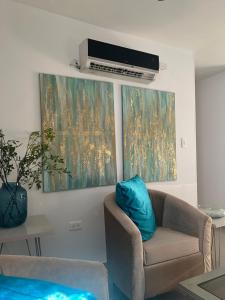 a living room with a couch and two paintings on the wall at Apartamento COMPLETO Nuevo Norte de Valledupar-1 Habitación, Balcón y Parqueadero in Valledupar